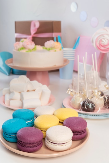 Arrangement de table pour un anniversaire avec gâteau et macarons