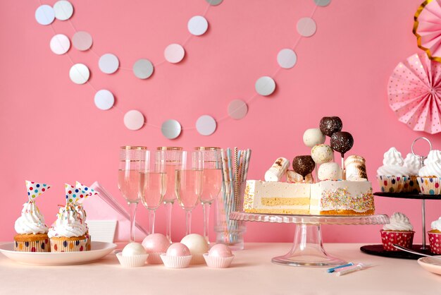 Arrangement de table pour un anniversaire avec gâteau et verres de champagne