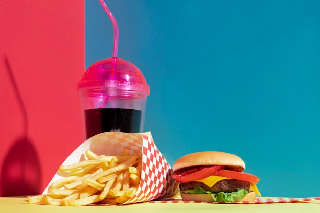 Arrangement avec une tasse de jus et un délicieux hamburger