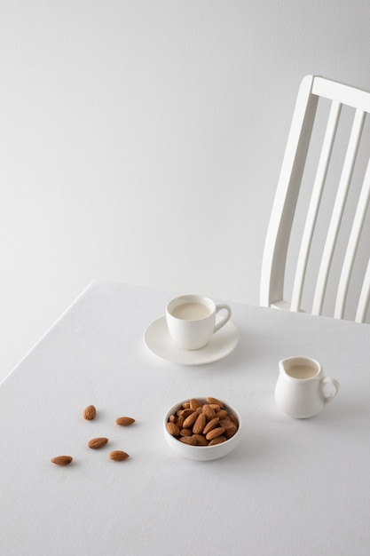 Photo gratuite arrangement de tasses à angle élevé et d'amandes