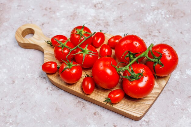 Arrangement de tomates assorties fraîches colorées sur une surface en béton