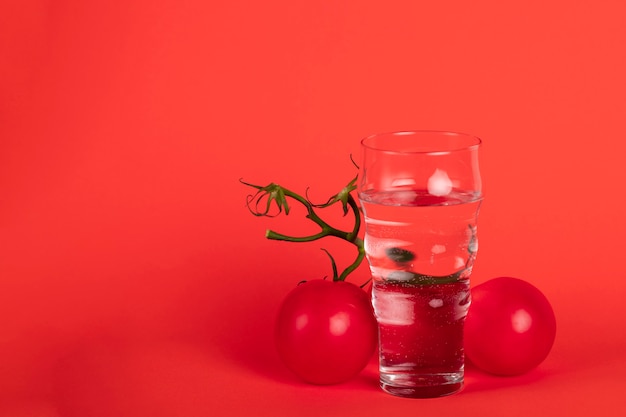 Arrangement avec verre, tomates et espace de copie