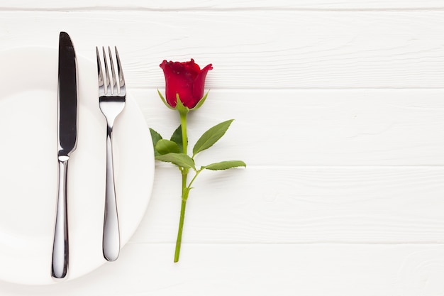 Arrangement vue de dessus avec assiette, couverts et rose