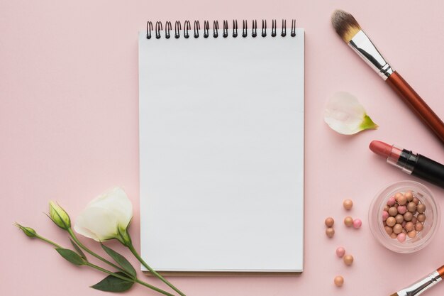 Arrangement de la vue de dessus avec produits de maquillage et cahier