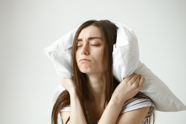 Arrêtez de faire ce son ennuyeux. Plan intérieur d'une jeune femme frustrée et bouleversée avec des cheveux en désordre souffrant d'insomnie ou d'un trouble du sommeil, ne peut pas se détendre à cause du son de l'eau qui coule irritant