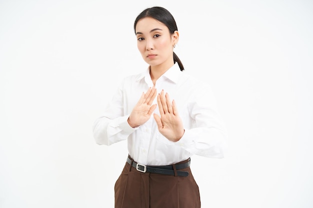 Photo gratuite arrêtez de rester en arrière jeune femme asiatique rejette qch s'éloigne tient les mains tendues pour refuser de désapprouver s