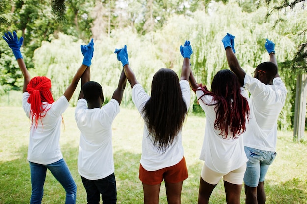 L'arrière du groupe de joyeux volontaires africains se tiennent la main dans le parc Africa bénévolat caritatif personnes et concept d'écologie