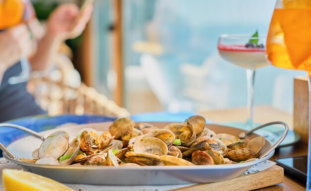 Arrière-plan flou avec un plat de palourdes vongole bouillies sur une table dans un café avec espace de copie Idée pour écran de démarrage ou bannière