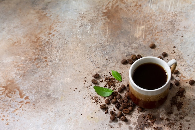 Arrière-plan avec une tasse de café et des grains sur une table en béton copiez l'espace