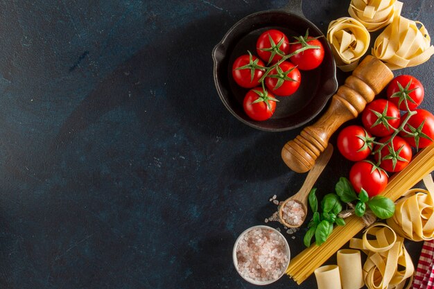 Arrière-plan avec des tomates fraîches et variété de pâtes
