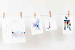 Photo gratuite art de la chromatographie esthétique sur papiers blancs suspendus à une corde