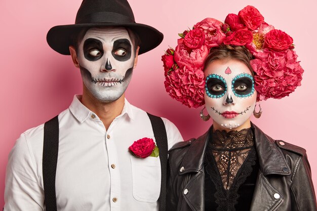 Art de visage d'Halloween. Femme et homme se tiennent ensemble en tenue mexicaine