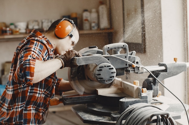 Artisan à l'aide d'une scie circulaire