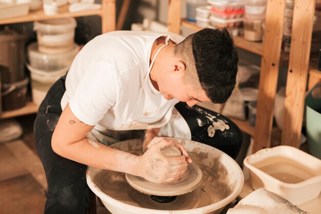 Artisan confectionnant un vase à partir d&#39;argile humide fraîche sur un tour de potier