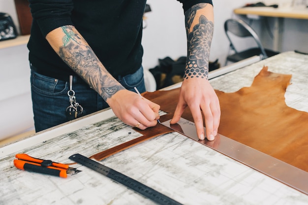 Artisan de cuir travaillant à faire des measupenets dans les modèles à la table dans le studio d&#39;atelier