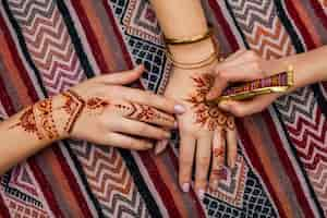 Photo gratuite artiste faisant mehndi sur womans main sur une table lumineuse