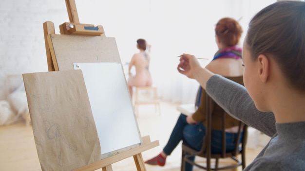 Artiste féminine esquissant un modèle nu dans un studio de dessin, gros plan