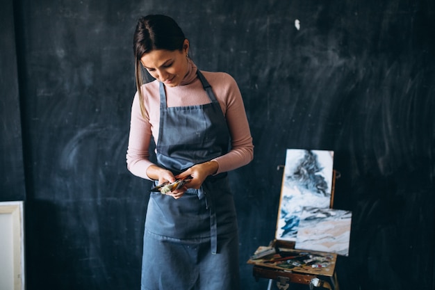 Photo gratuite artiste féminine peignant en studio