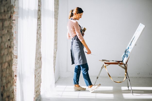 Artiste féminine peignant en studio