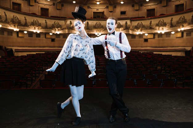 Artiste masculin pointant le doigt à l&#39;artiste mime femme debout sur scène