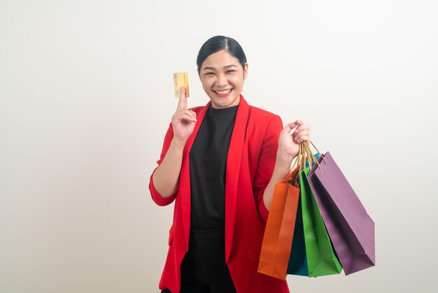 Asian woman holding shopping bag et carte de crédit en main avec fond blanc