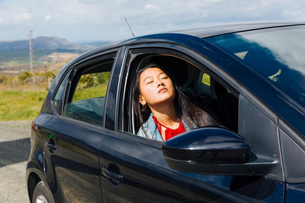 Asiatique femme assise dans la voiture et profiter du soleil