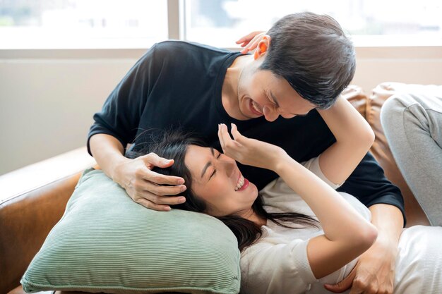 Asiatique se marier Couple amoureux partageant de véritables émotions et bonheur étreindre sur canapé canapé lumière du matin dans le salon intérieur fond maison concept d'isolement