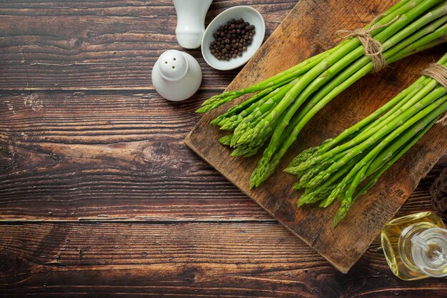 Asperges vertes fraîches sur fond de bois