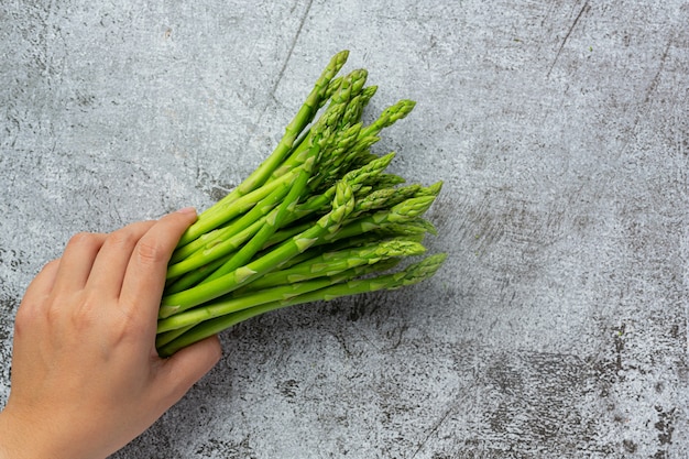 Asperges vertes fraîches sur fond sombre ancien