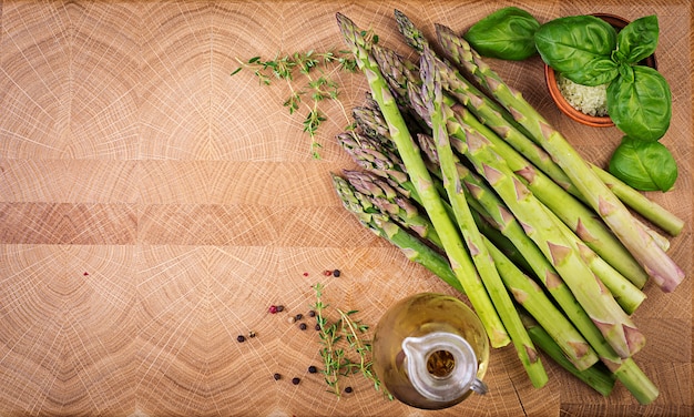 Asperges vertes fraîches sur une table en bois rustique avec espace copie. Vue de dessus