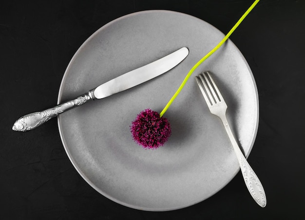 Assiette avec des appareils et une fleur d'ail sauvage