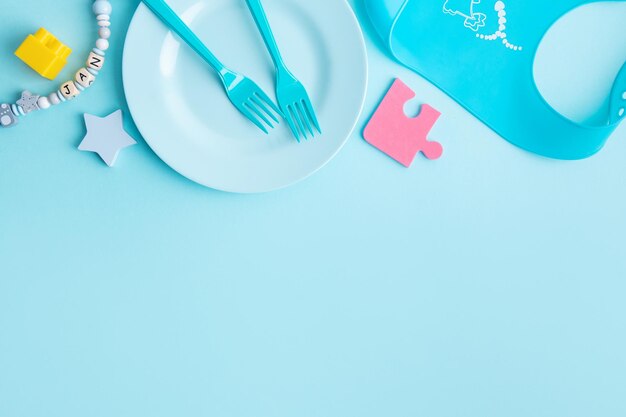 Assiette bébé bleu avec couverts sur table