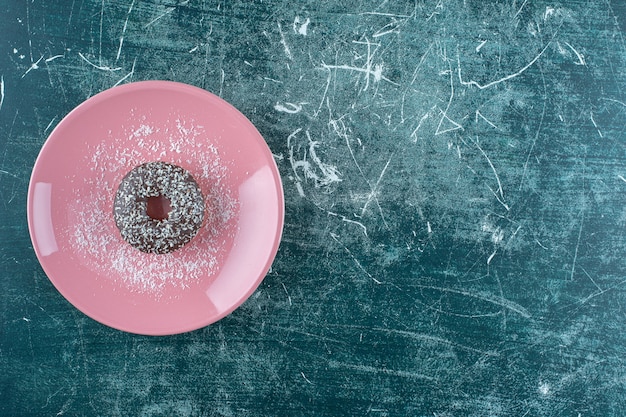 Une assiette de beignet au chocolat, sur fond bleu. photo de haute qualité