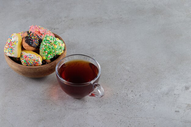 Une assiette de biscuits en forme de coeur avec des pépites et une tasse de thé chaud