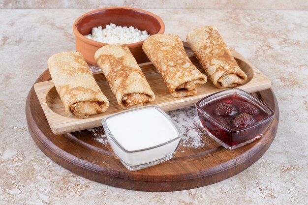 Une assiette blanche de crêpes savoureuses et confiture de fraises