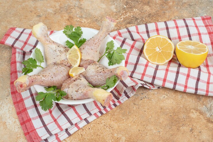 Photo gratuit une assiette blanche de cuisses de poulet avec des tranches de citron