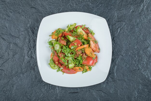 Une assiette blanche de délicieuse salade de légumes.