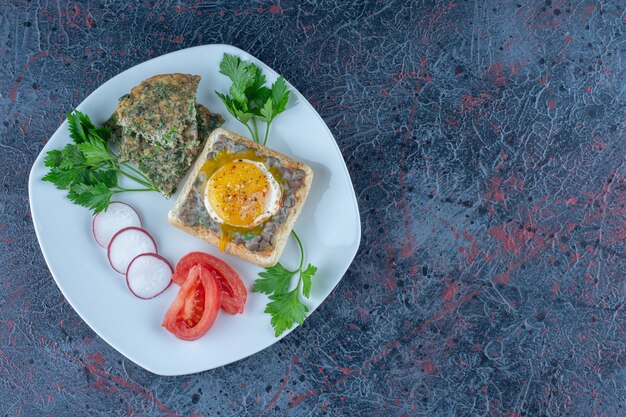 Une assiette blanche de délicieux toasts avec de la viande et des légumes