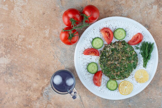 Une assiette blanche avec des légumes et une tasse de jus