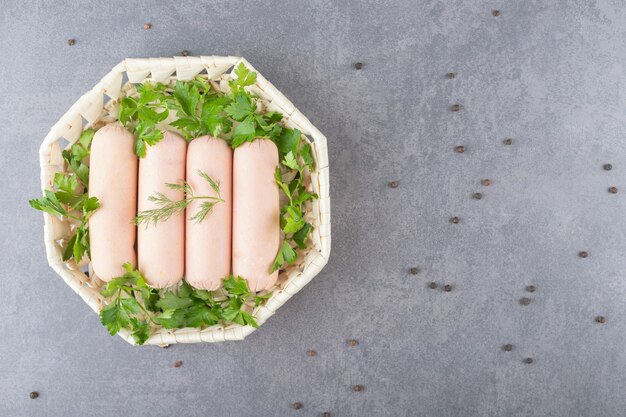 Une assiette blanche de saucisses bouillies avec du persil