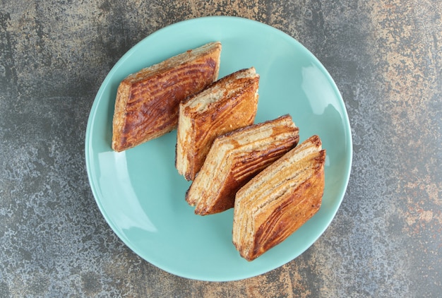 Une assiette bleue de tartes triangle sucrées maison