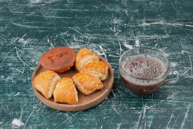 Assiette en bois de boulangerie avec thé chaud sur table en marbre