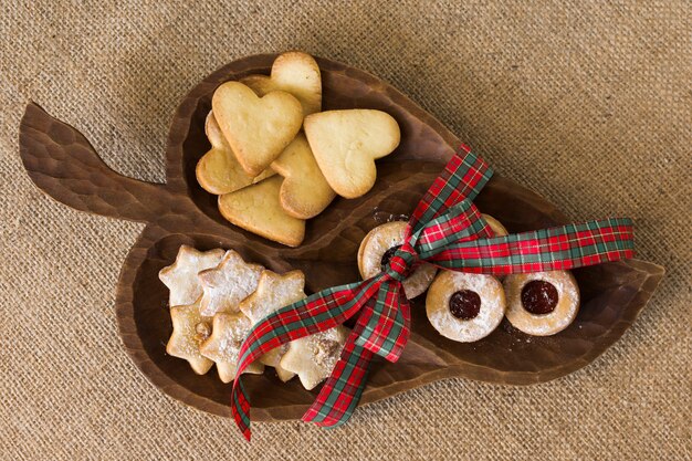 Assiette en bois avec différents biscuits sur la table