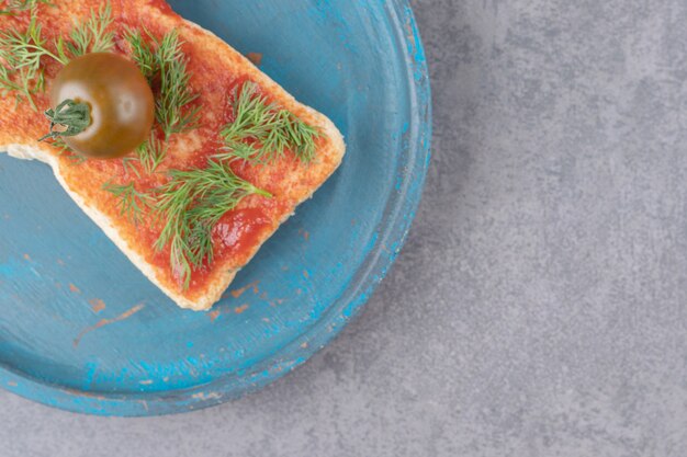 Une assiette en bois avec du pain grillé sur une surface en marbre