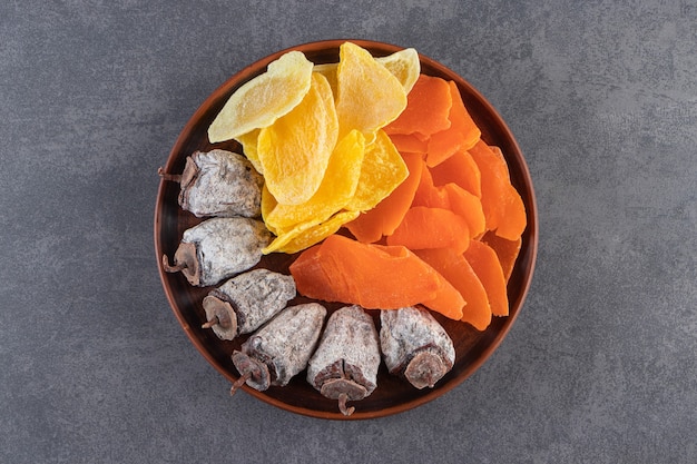 Une Assiette En Bois Pleine De Fruits Secs Sains Mélangés Placés Sur Une Table En Pierre.