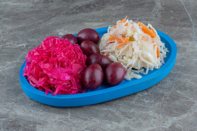 Assiette en bois pleine de rose et de choucroute et de palmier.