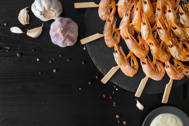 Photo gratuite assiette avec brochettes de crevettes et ail