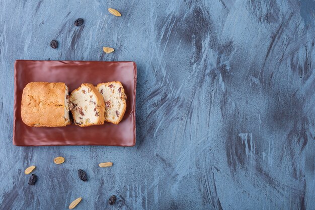 Assiette Brune De Gâteau Aux Raisins En Tranches Sur Une Surface En Marbre.