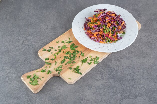 Assiette de chou haché et carottes sur planche de bois. photo de haute qualité