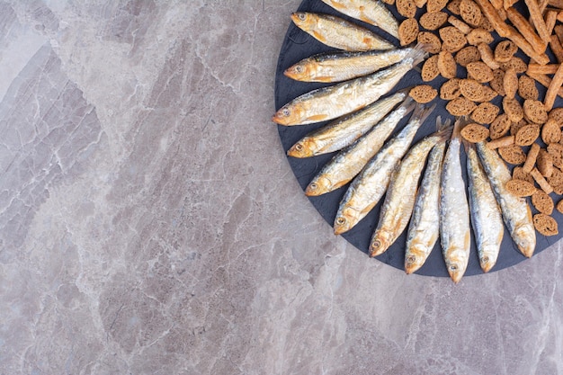 Assiette de collations de poisson et de craquelins sur une surface en marbre. photo de haute qualité